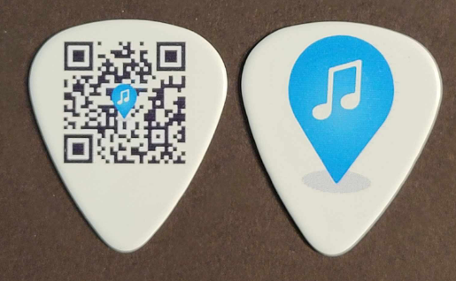 A white Subjam branded guitar pick, on one side is a QR code that goes to https://subj.am and the other side with the blue location and musical note marker pin logo.